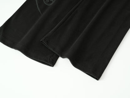 Close-up of a black fabric garment, likely a shirt or shorts, folded to show the texture and hem on a white background.